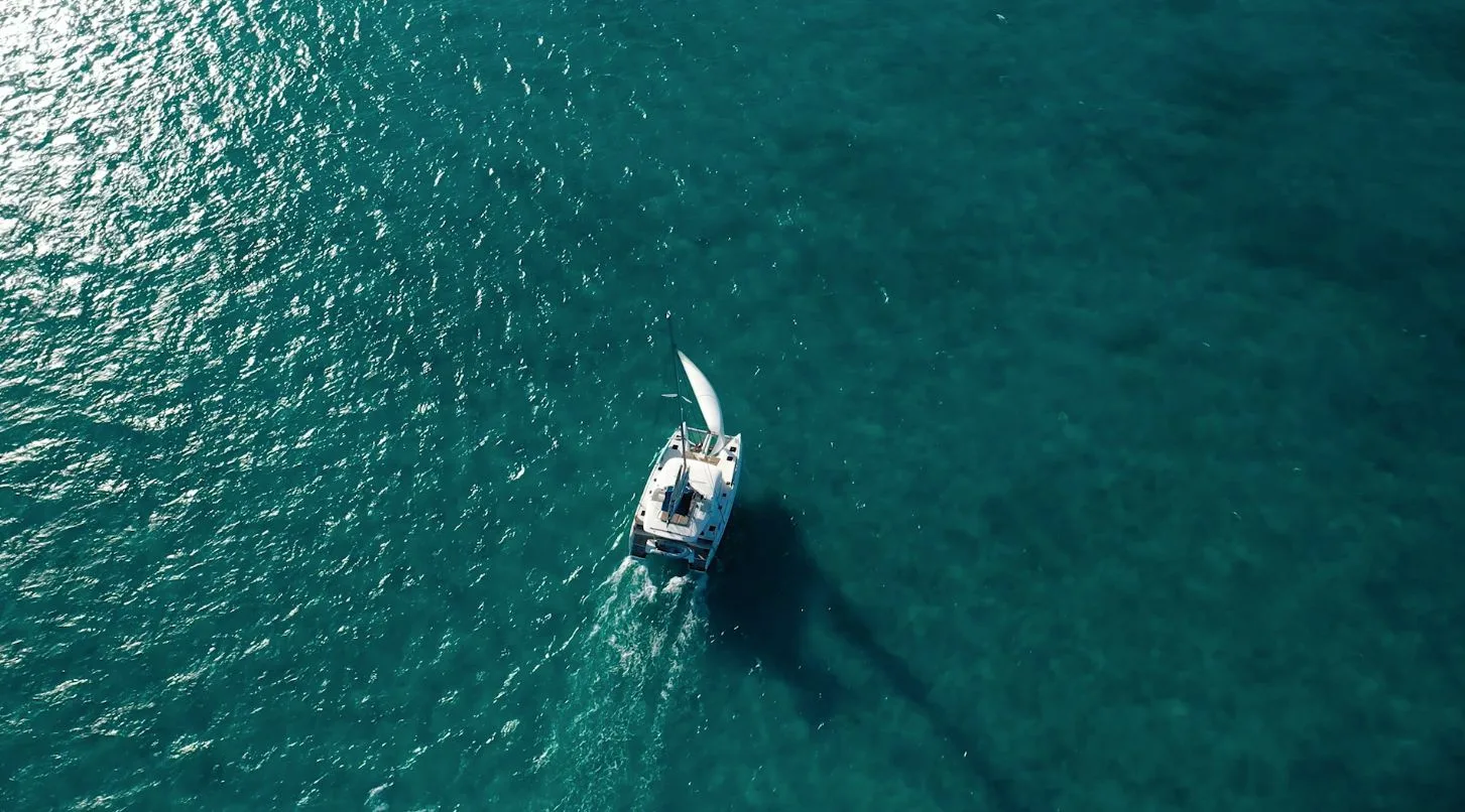 Aerial view of a catamaran under sail on the turquoise Sea of Abaco