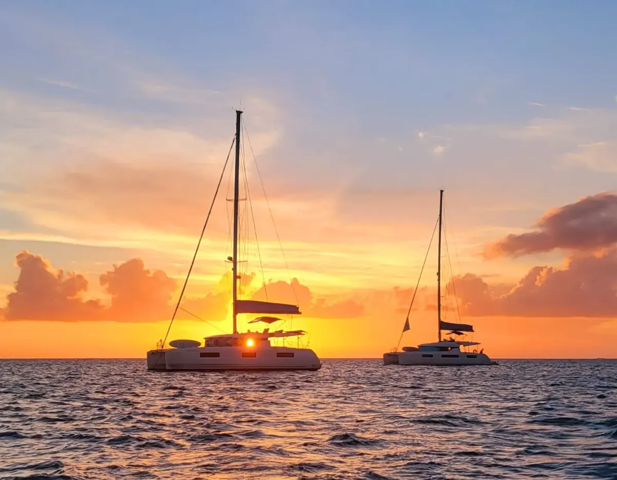 Catamarans at anchor as the sun goes down over the Sea of Abaco