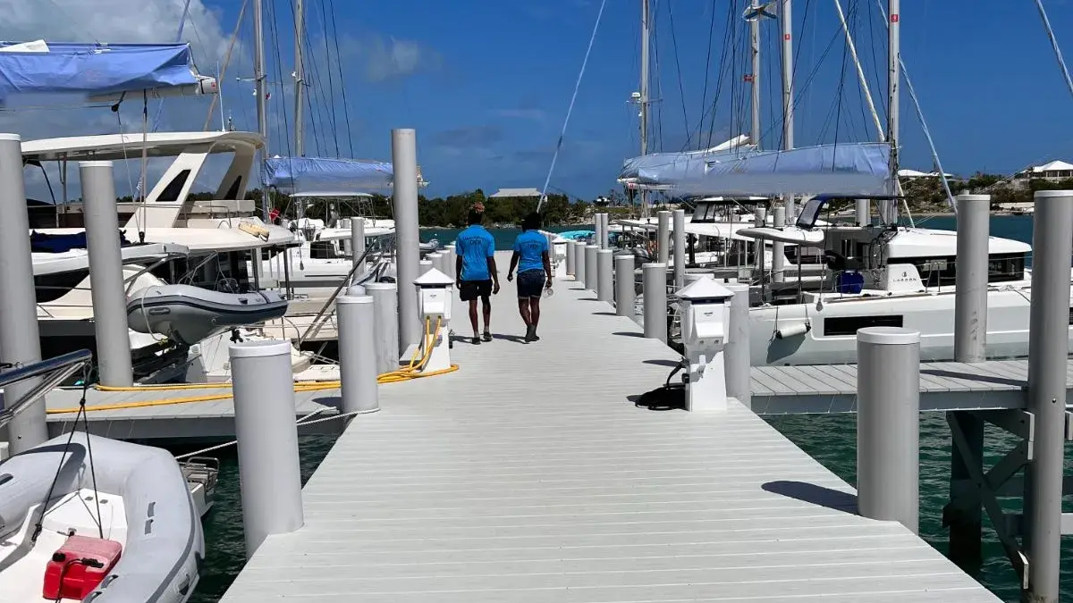 Two of our crew walking the dock at Conch Inn marina, catamarans tied up on both sides