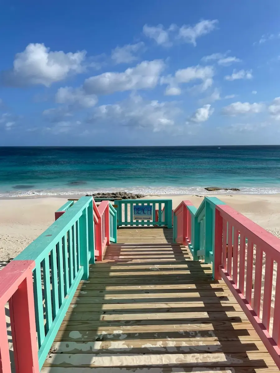 Pastel pink and green stairs leading down to the Atlantic beach below Nipper's