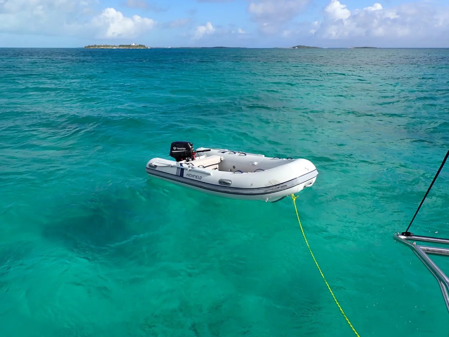 The tender astern of Ptarmigan in clear Abaco water
